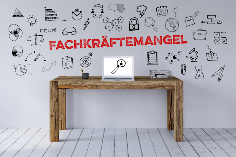 Schriftzug Fachkräftemangel über Schreibtisch Arbeitsplatz